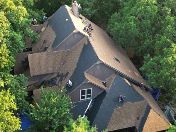 Aerial view of a Mid Cities Roofing crew replacing the roof on a large home in Weatherford, TX